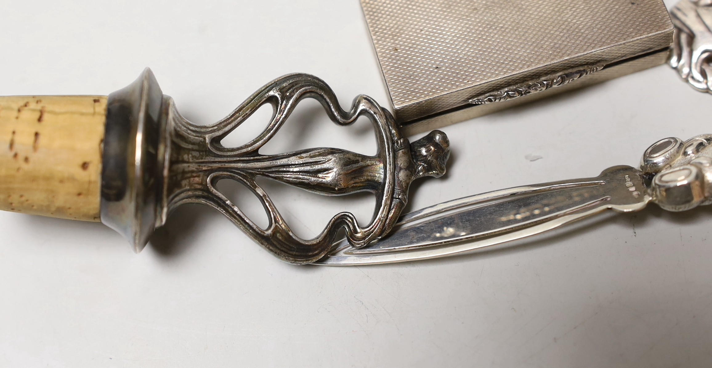 An Art Nouveau metal mounted cork stopper, a Georg Jensen sterling brooch, no. 191, an engine turned silver box and novelty bookmark.